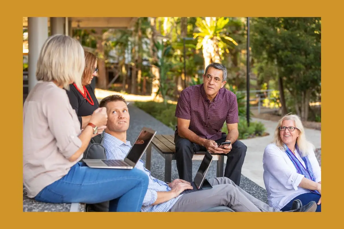 5 family members sitting outdoors having a serious discussion